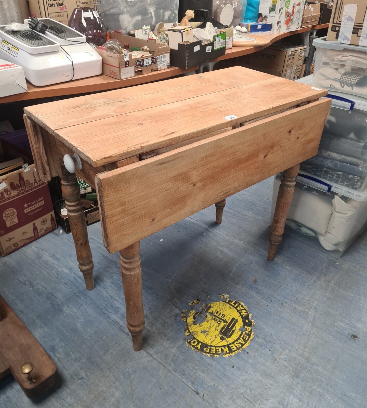 Antique pine drop leaf table with hinged leaves and turned legs.