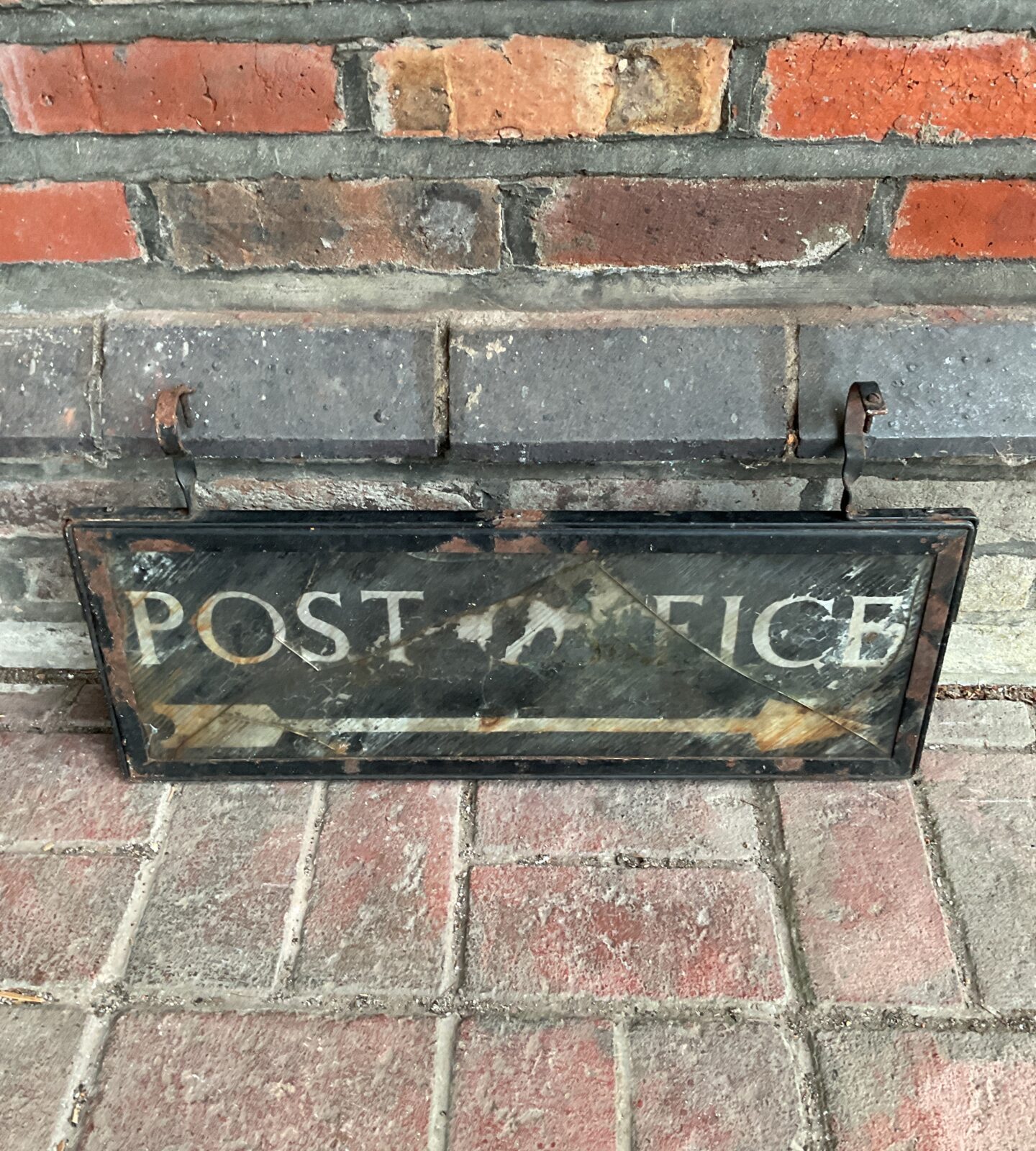 Close up of antique post office sign, showing detail and weathering.