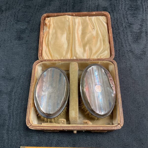 Antique hallmarked silver brushes in velvet case.