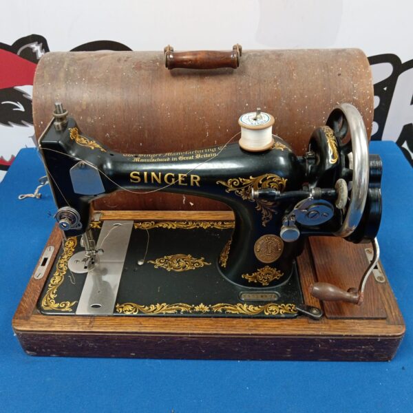 Antique Singer sewing machine with ornate detailing and hand crank.