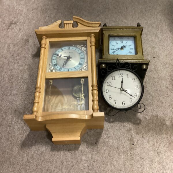 Antique wall clock with a wooden case and decorative face.