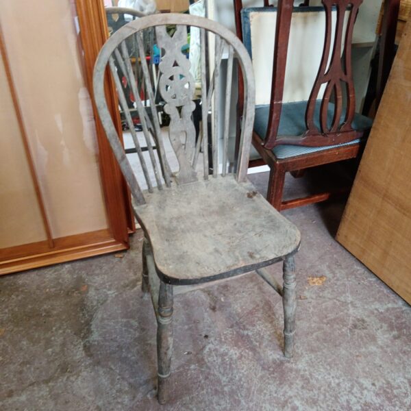 Antique wheelback chair with wooden seat and turned legs.
