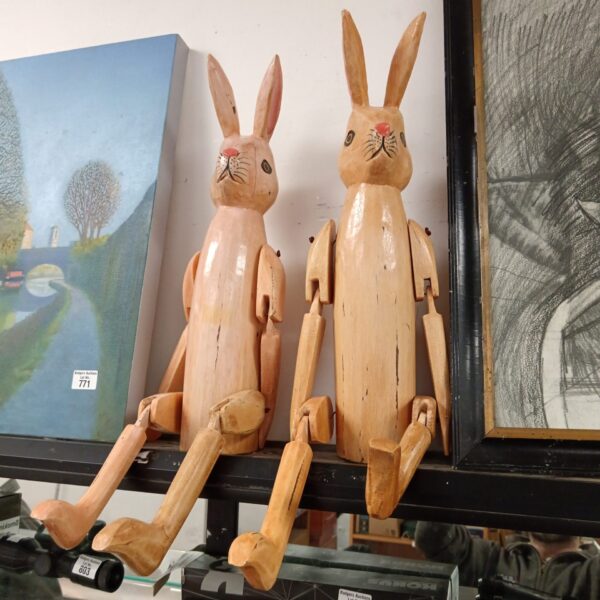 Pair of antique wooden rabbit marionettes with articulated limbs.