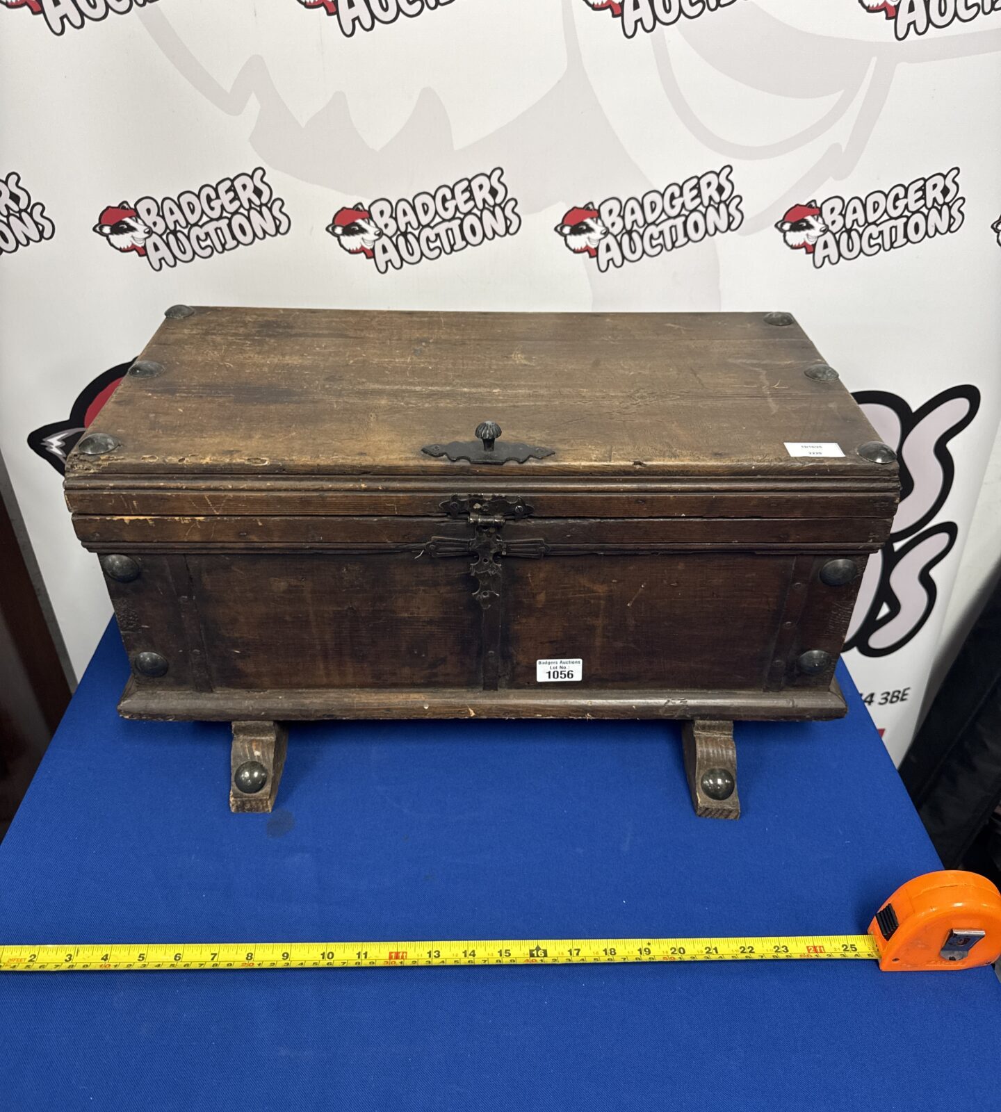 Front view of antique wooden storage box with metal clasp.