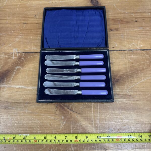 Cased set of six Art Deco silver-plated butter knives with lilac handles.