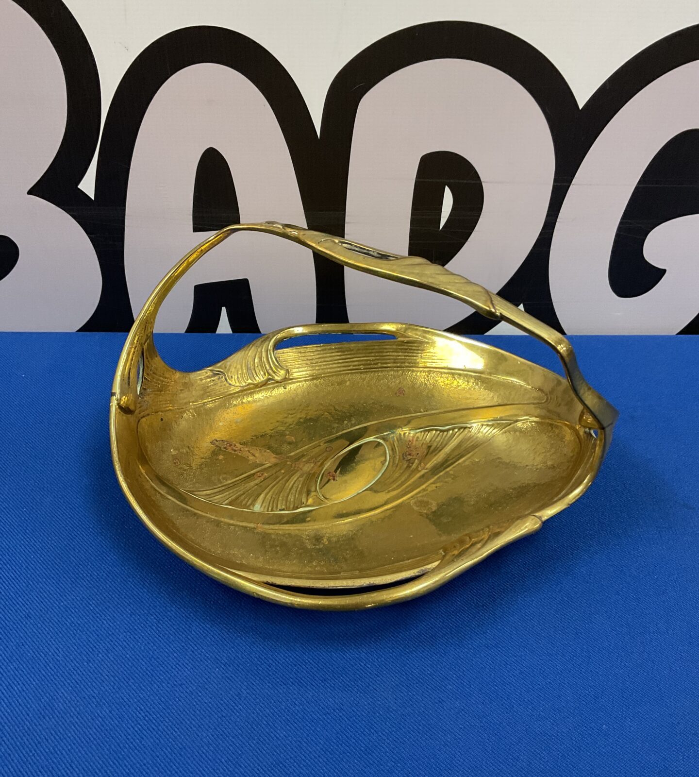 Vintage Art Nouveau brass dish with a delicate handle.