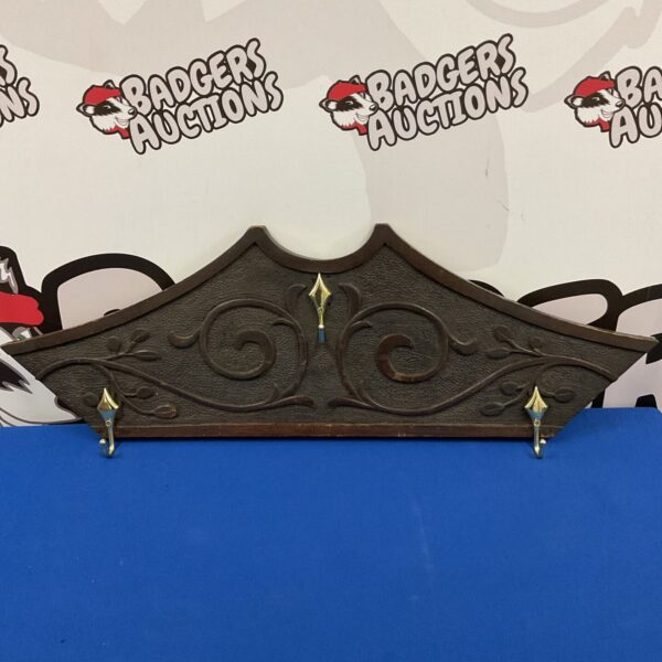 Vintage Art Nouveau coat rack with intricate carved wood details.