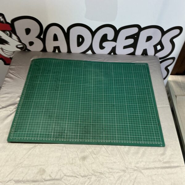 Green artist cutting mat with grid lines for crafting.