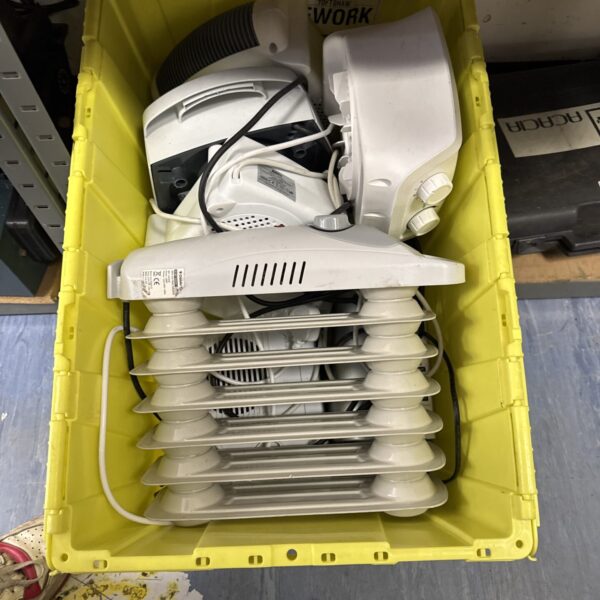 Assorted electric heaters in a tote crate, portable heating appliances.
