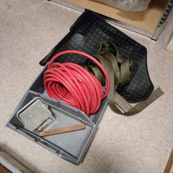 Automotive storage lot with hose, strap, and trays.