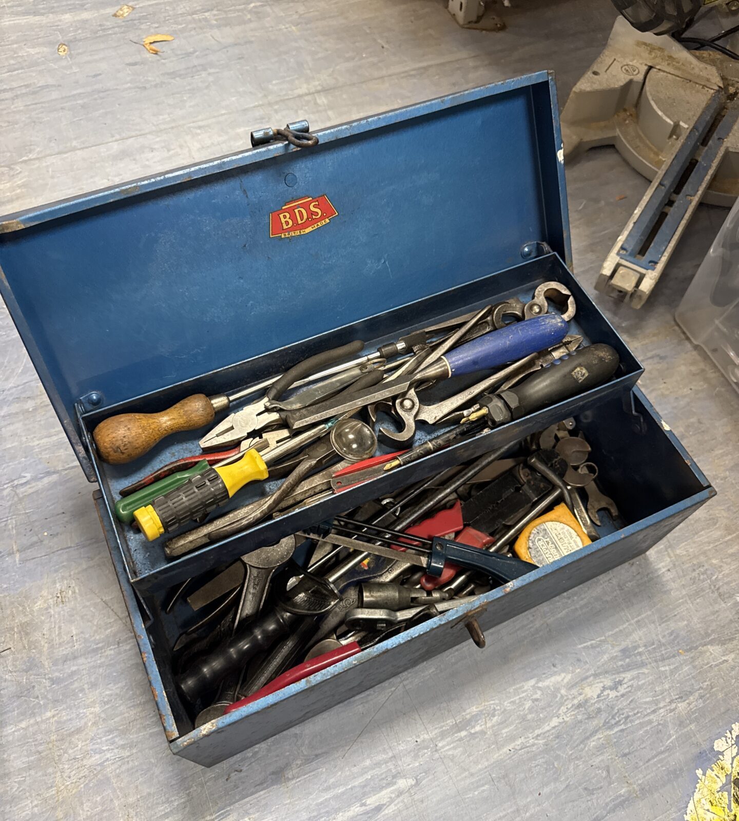 Vintage BDS metal toolbox filled with various hand tools.