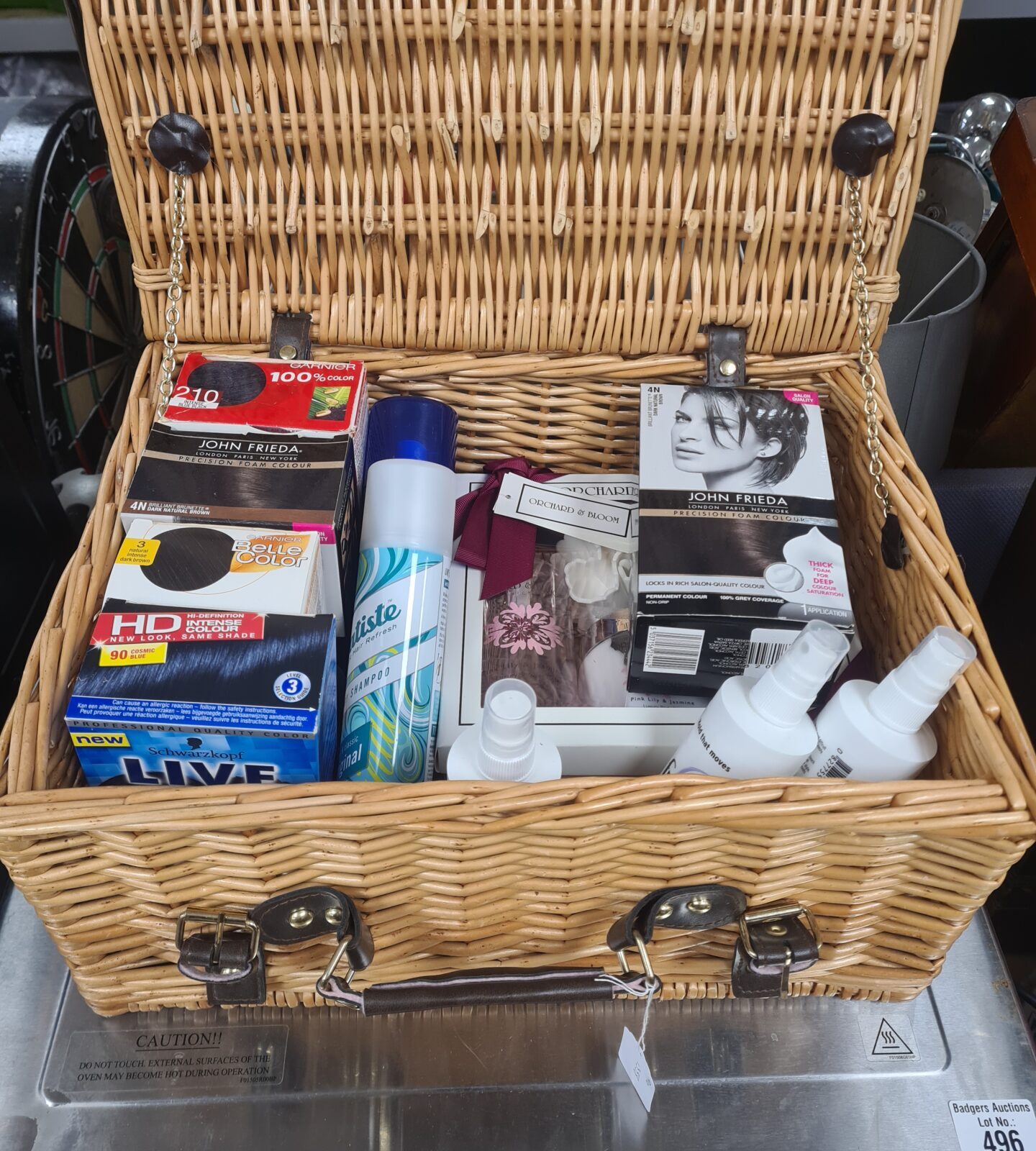 Wicker basket filled with a mixed lot of beauty products and cosmetics.