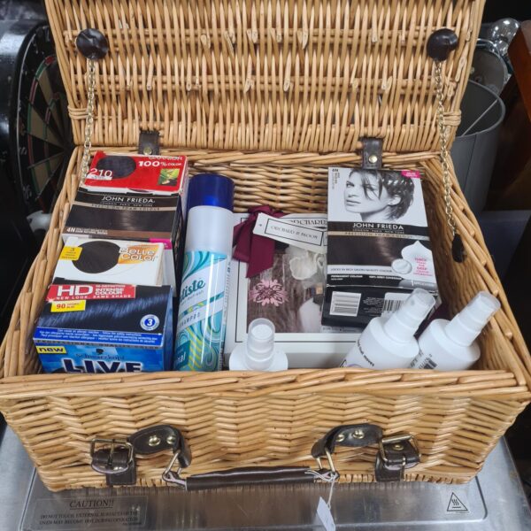 Wicker basket filled with a mixed lot of beauty products and cosmetics.