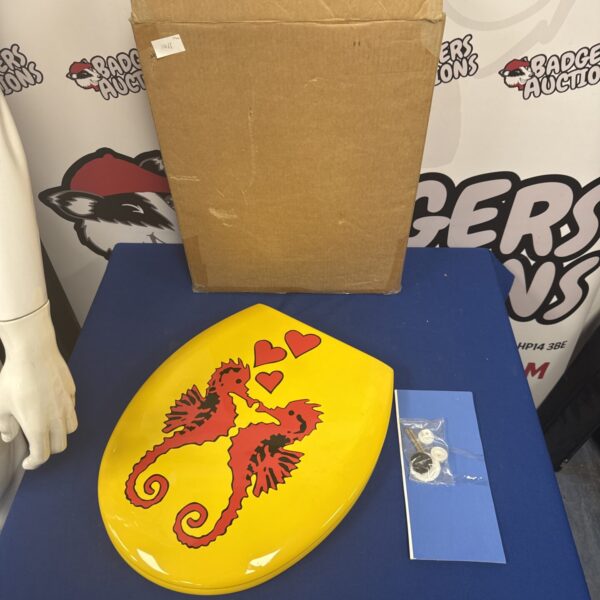 Front view of a yellow Bemis seahorse toilet seat with heart details.