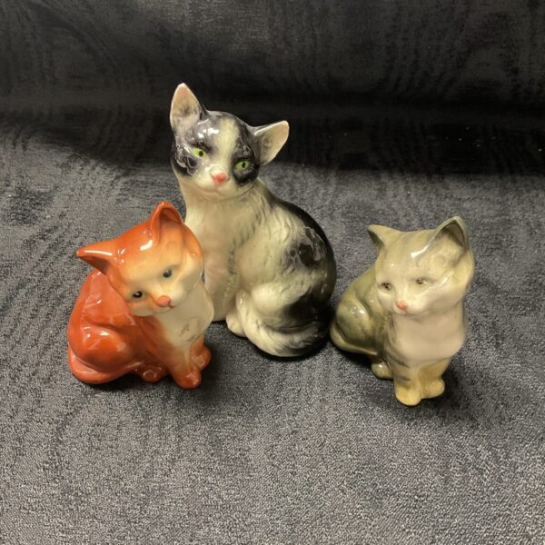 Vintage Beswick and Goebel ceramic cat figurines on display.
