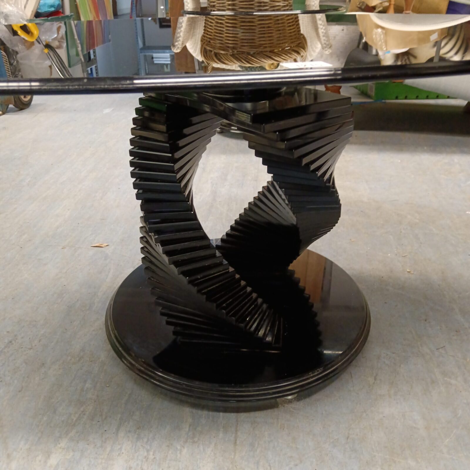 Close-up of the black helix base on a smoked glass coffee table.