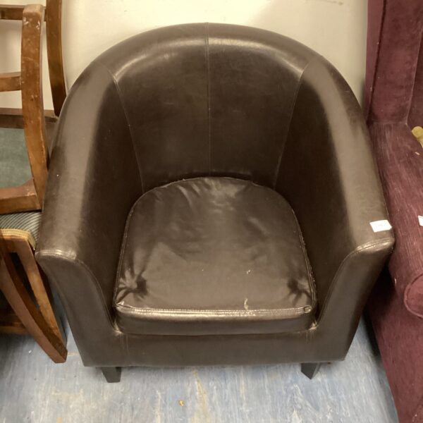 Black leather tub chair with a rounded design.