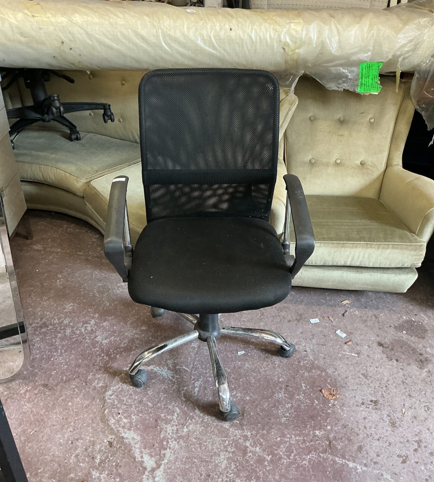 Black mesh office chair with swivel base and casters.