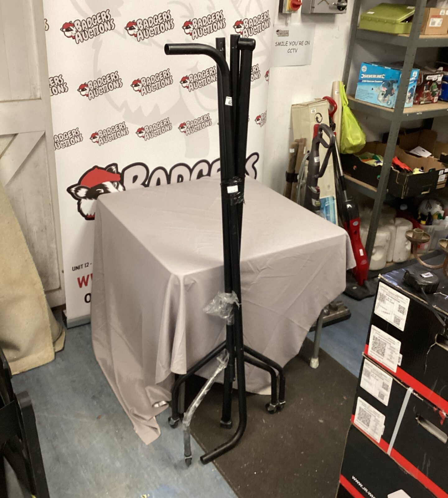 Black metal clothing rail for garment display in a retail setting.