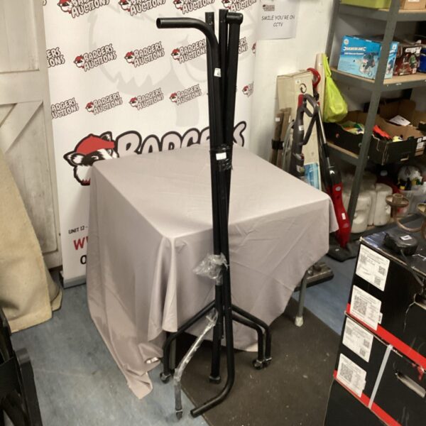 Black metal clothing rail for garment display in a retail setting.
