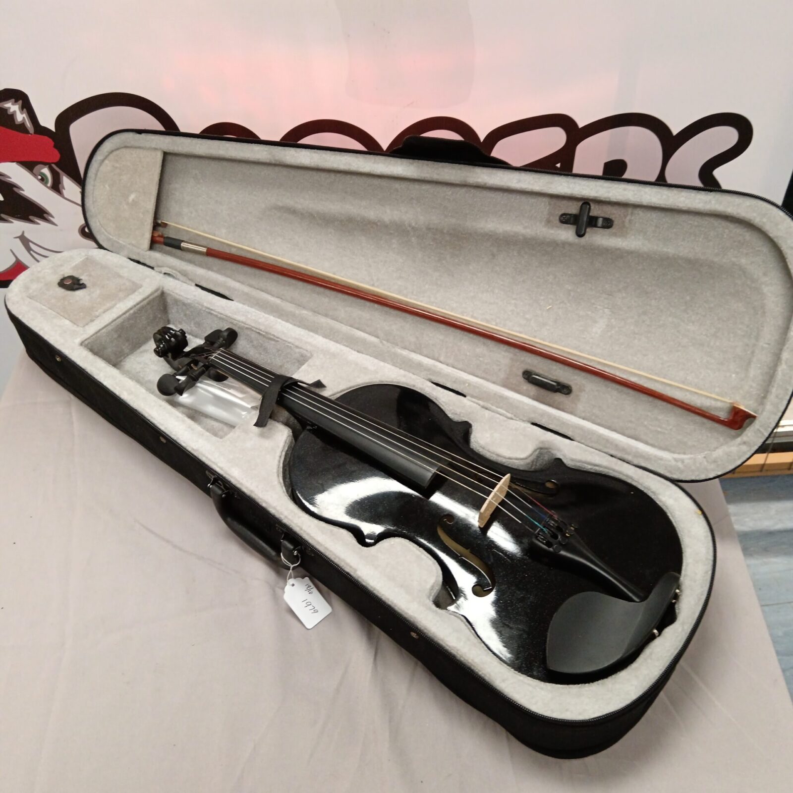 Black violin in open case with bow, complete set.