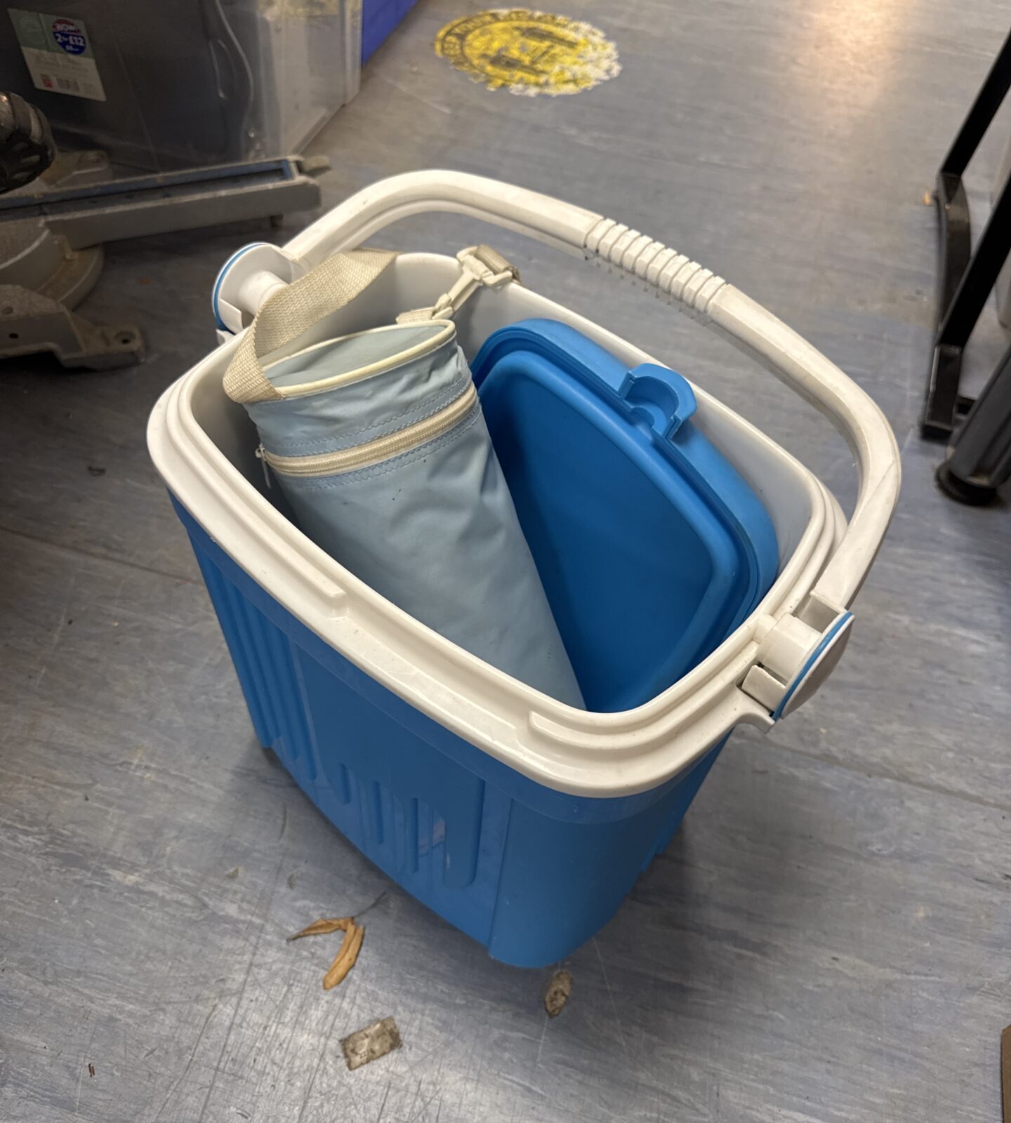 Bright blue cooler box with white bottle cooler inside.
