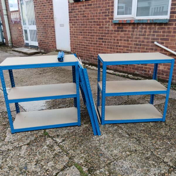 Three blue metal shelving racks for storage.