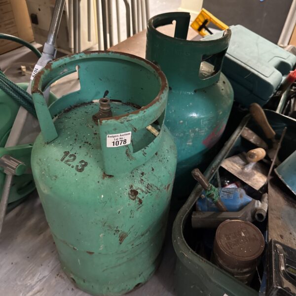 Blue steel patio gas canister with valve fitting.