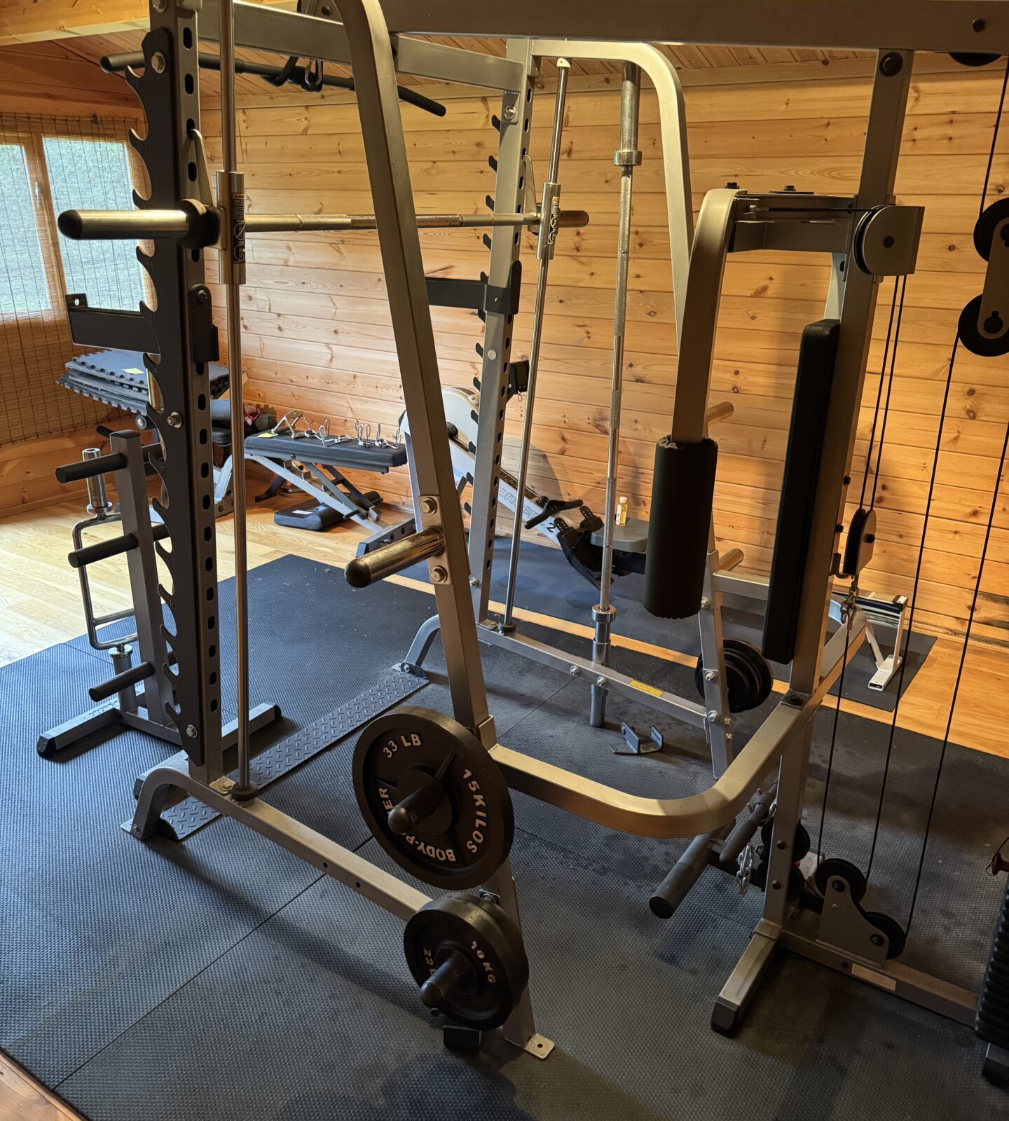 Weight plates stacked near the Body Solid multi gym.