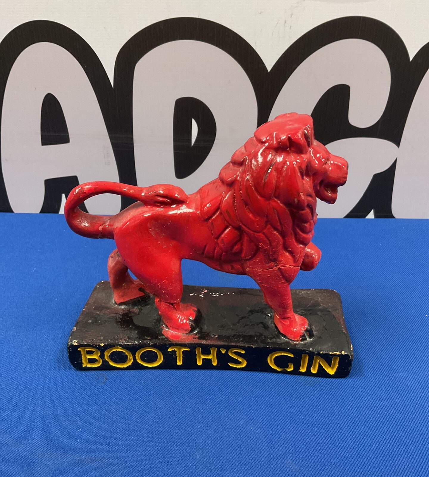 Vintage red chalkware lion advertising Booth's Gin.