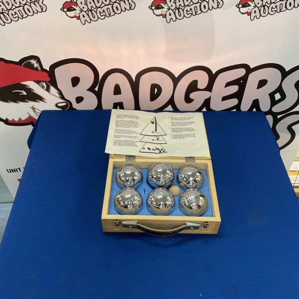 Vintage metal boules set in wooden case for lawn bowls.