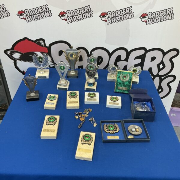 Collection of vintage bowls trophies and medals on display.