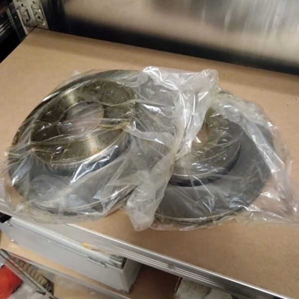 Pair of used vehicle brake discs for automotive repair.