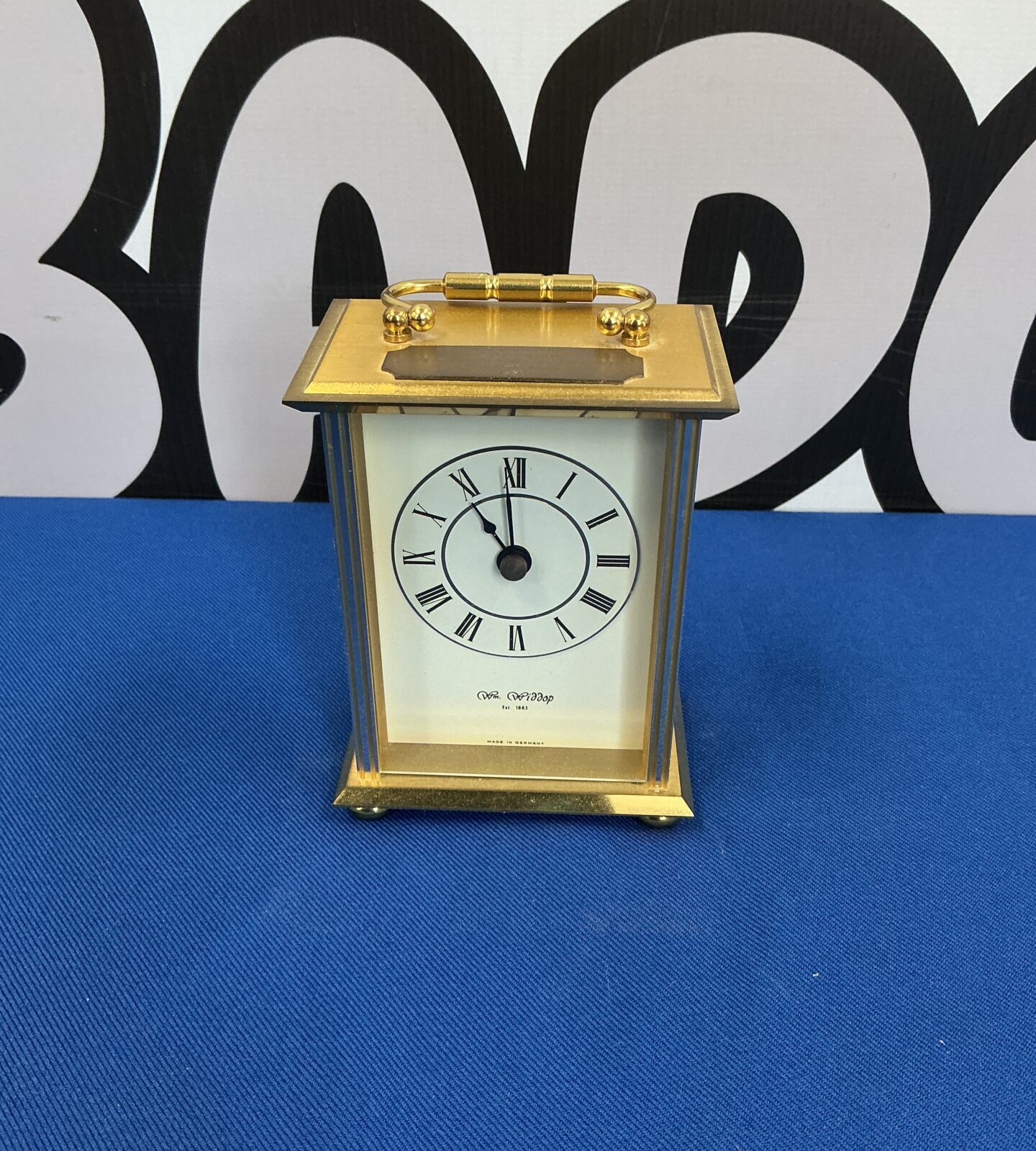 Elegant brass carriage clock by Wm Widdop with Roman numerals.