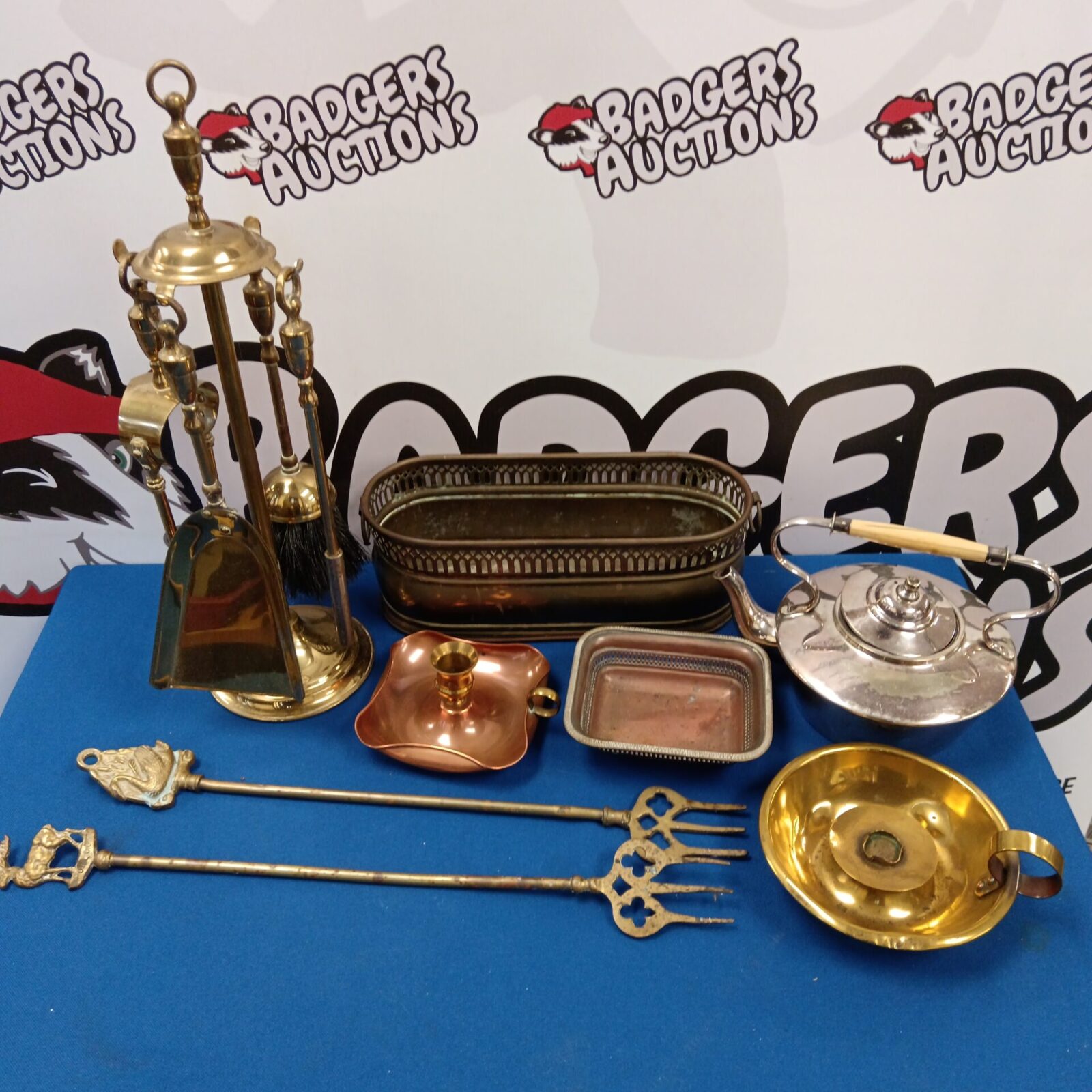 Overview of a mixed brass and copper lot with fireplace tools.