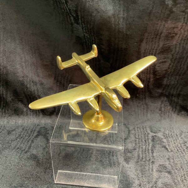 Detailed brass Lancaster bomber model on clear base.