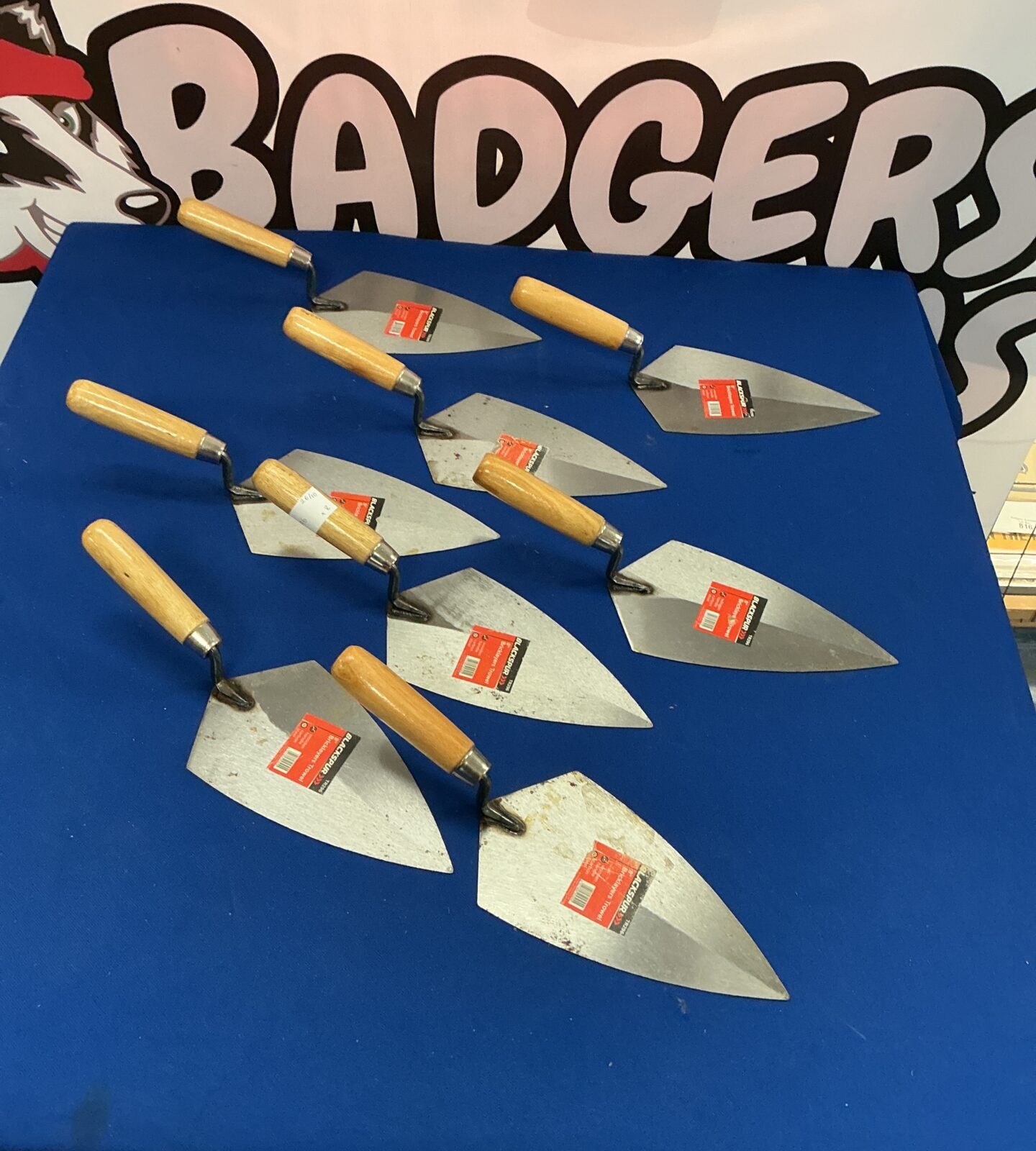 Lot of eight stainless steel bricklayers trowels with wooden handles.