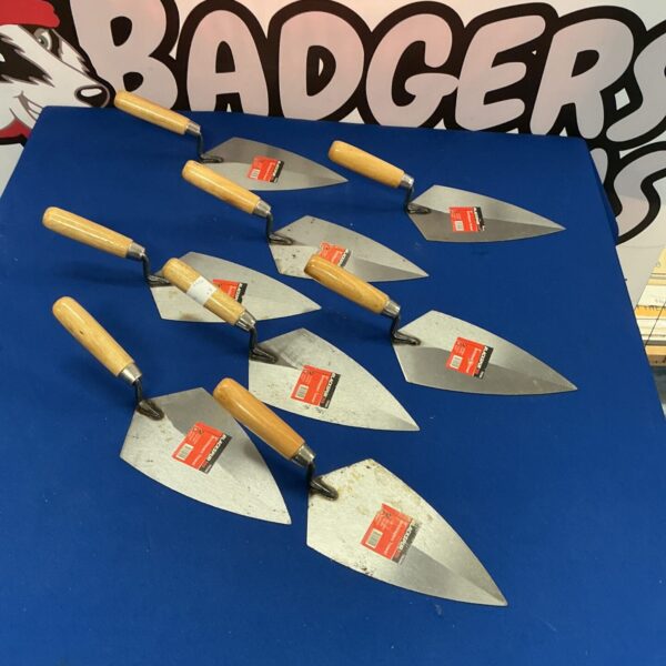 Lot of eight stainless steel bricklayers trowels with wooden handles.