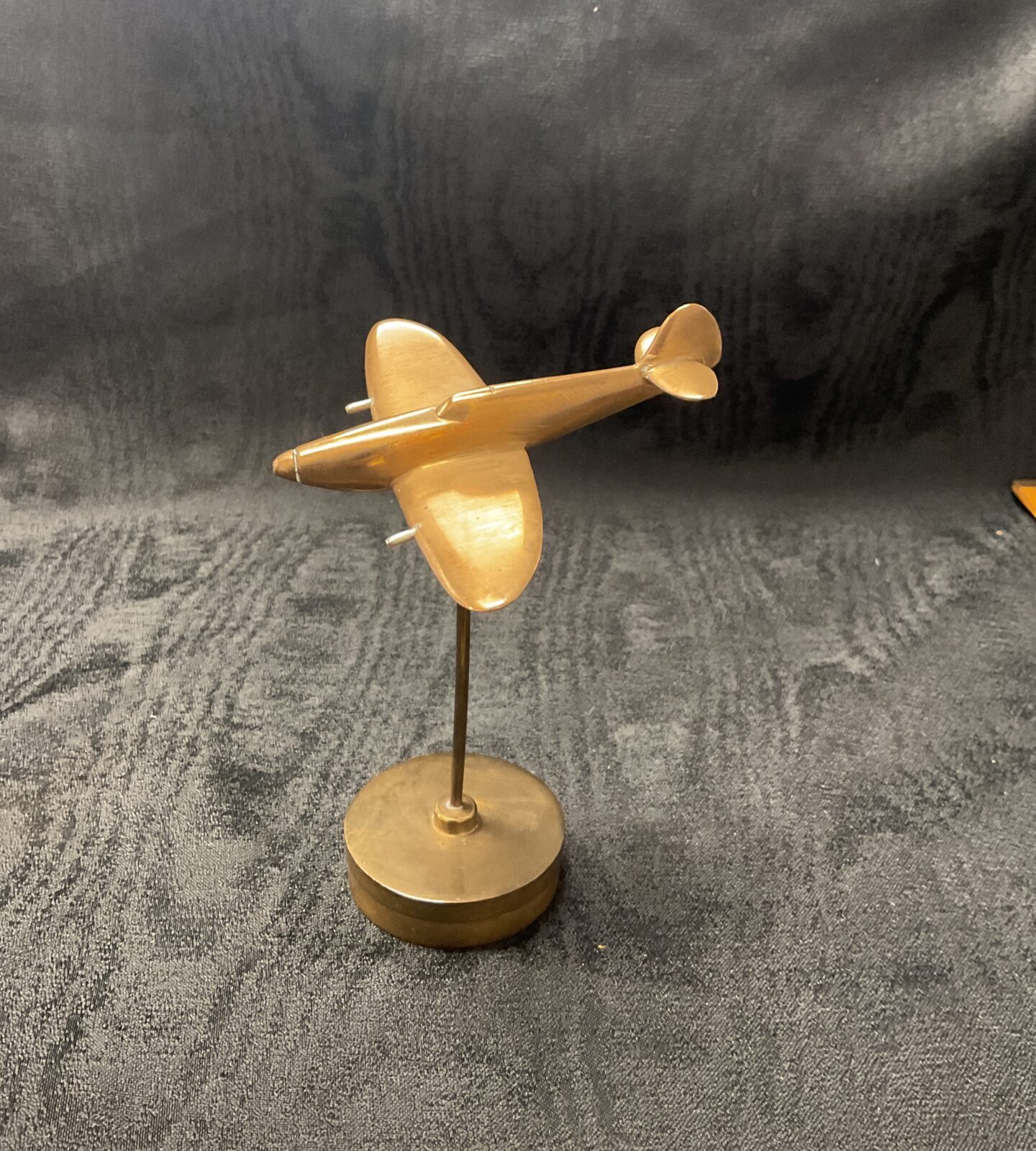 Detailed bronze Spitfire model on a circular base.