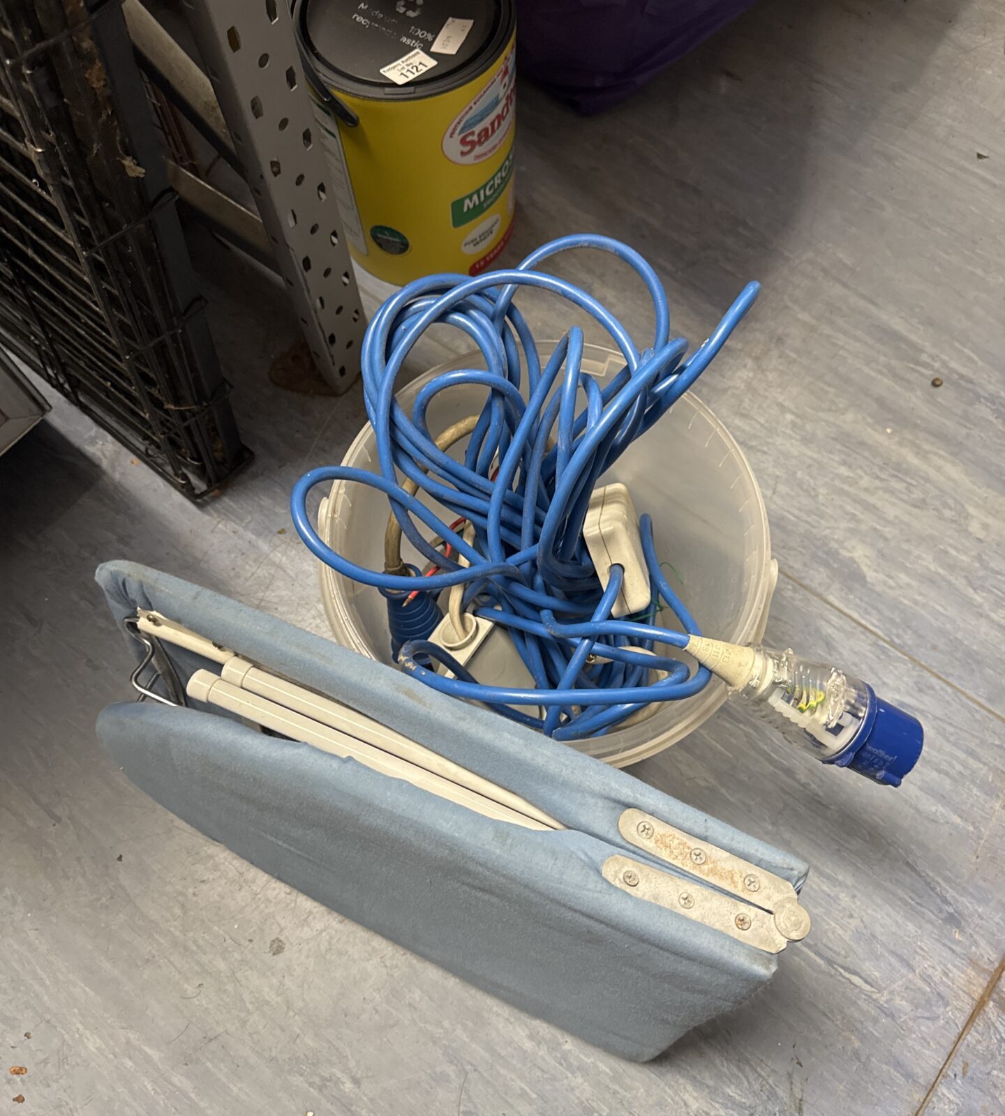 Assorted camping power leads and a folding ironing board for caravans.