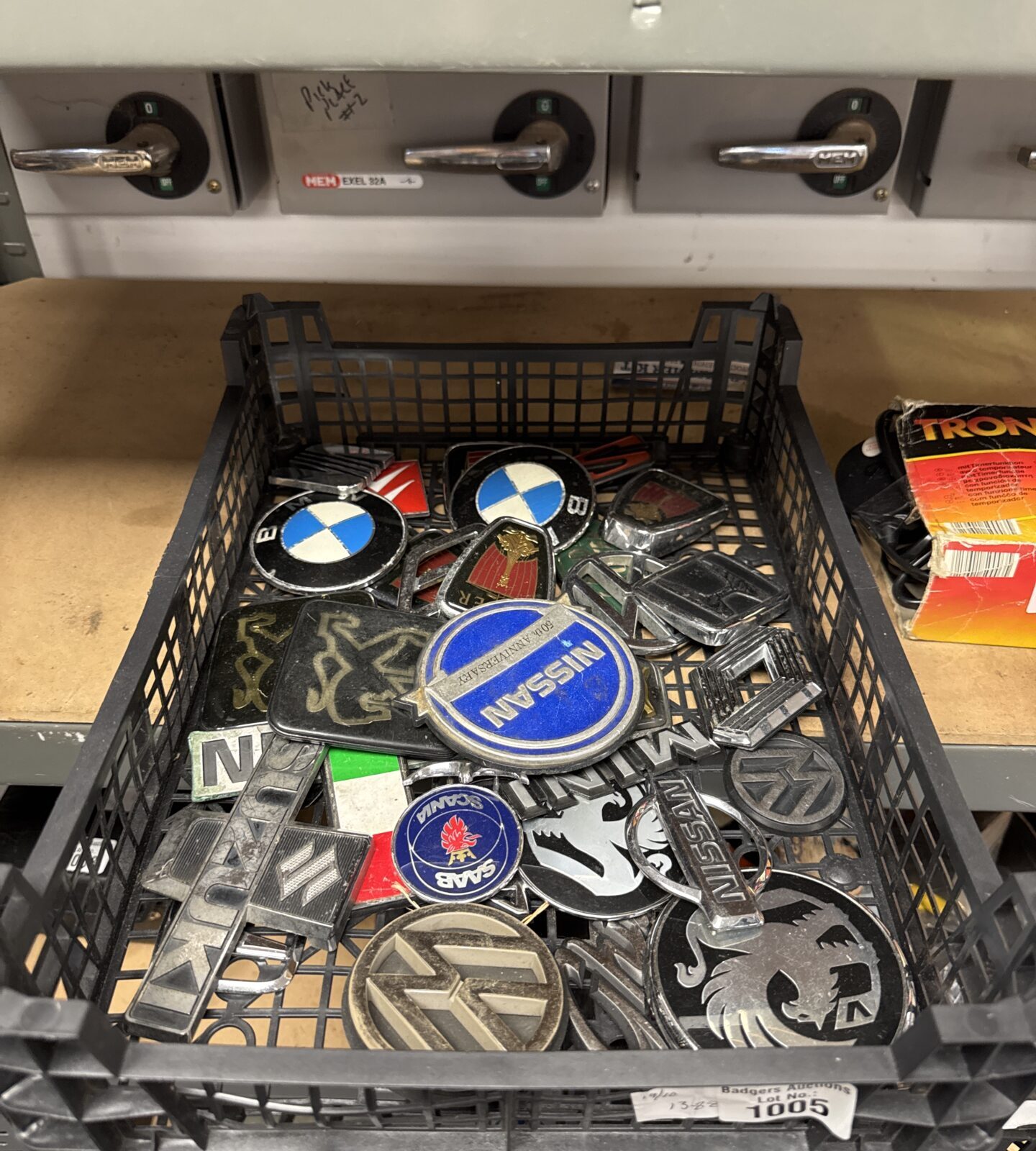 Tray of assorted vintage car badges and emblems.