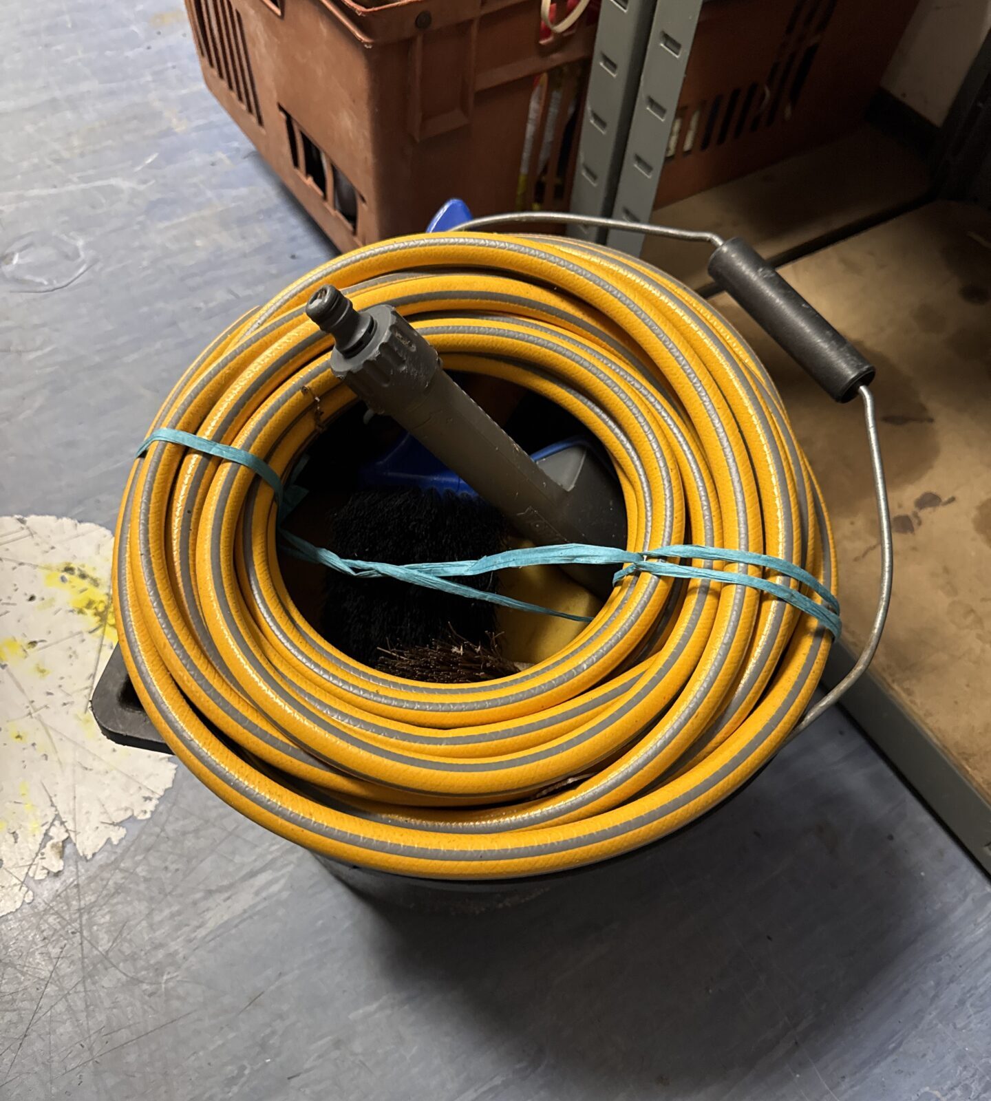 Yellow hosepipe and blue bucket in a car cleaning bundle.