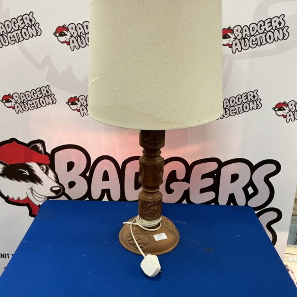 Vintage carved wood table lamp with intricate detailing.