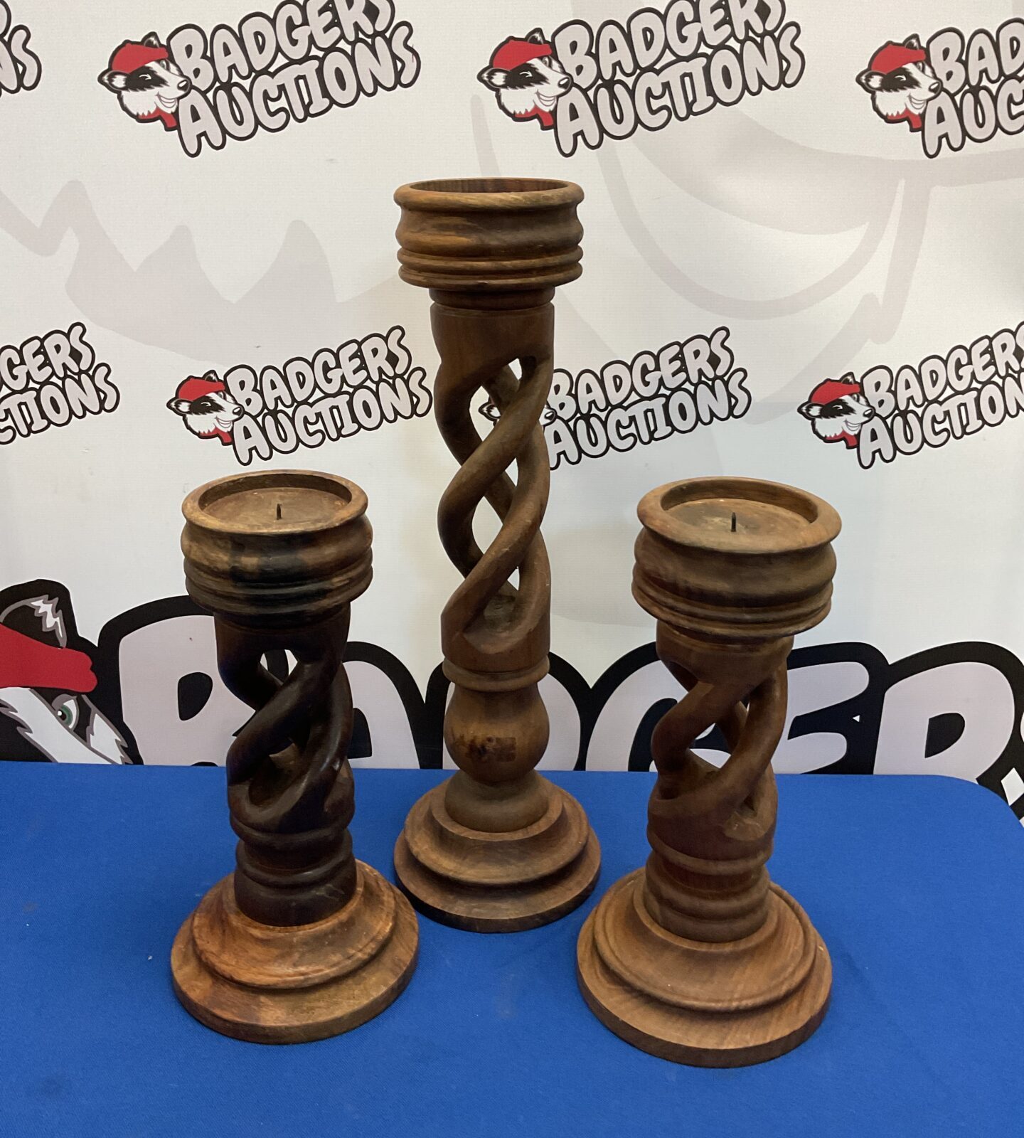 Three large carved wooden candlesticks with a twisted design.