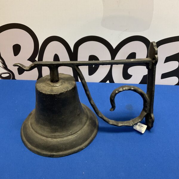 Dark cast iron bell with wall mounting bracket for garden or porch.