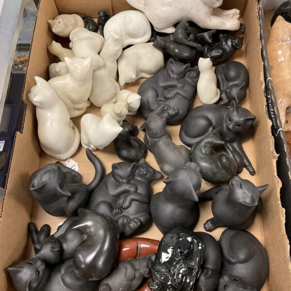 Large collection of black and white ceramic cat figures for collectors.