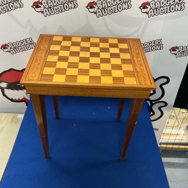 Vintage chessboard table with checkered top and turned legs.
