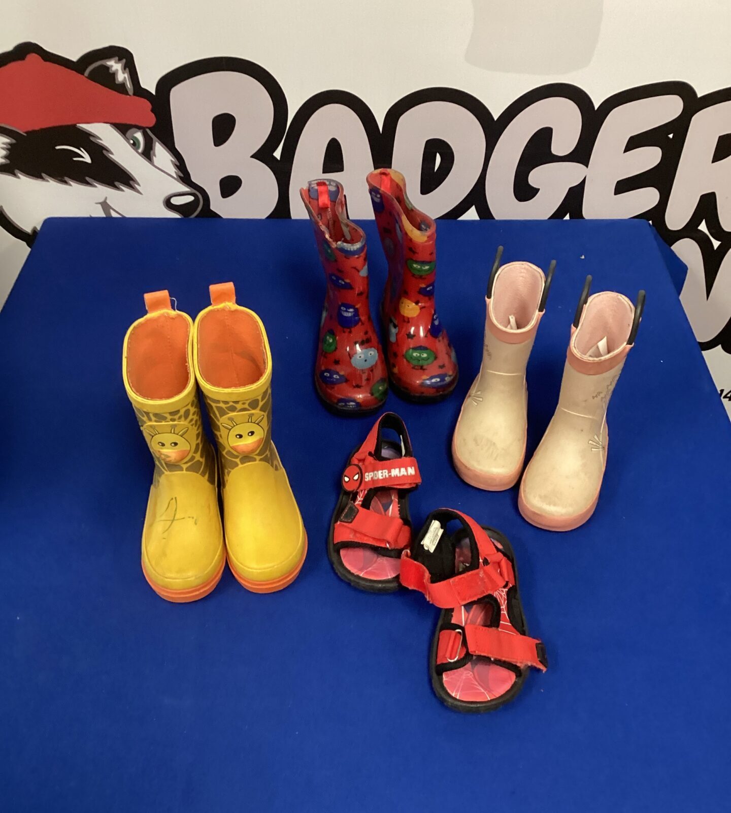 Colourful children's wellington boots and Spider-Man sandals lot for outdoor play.