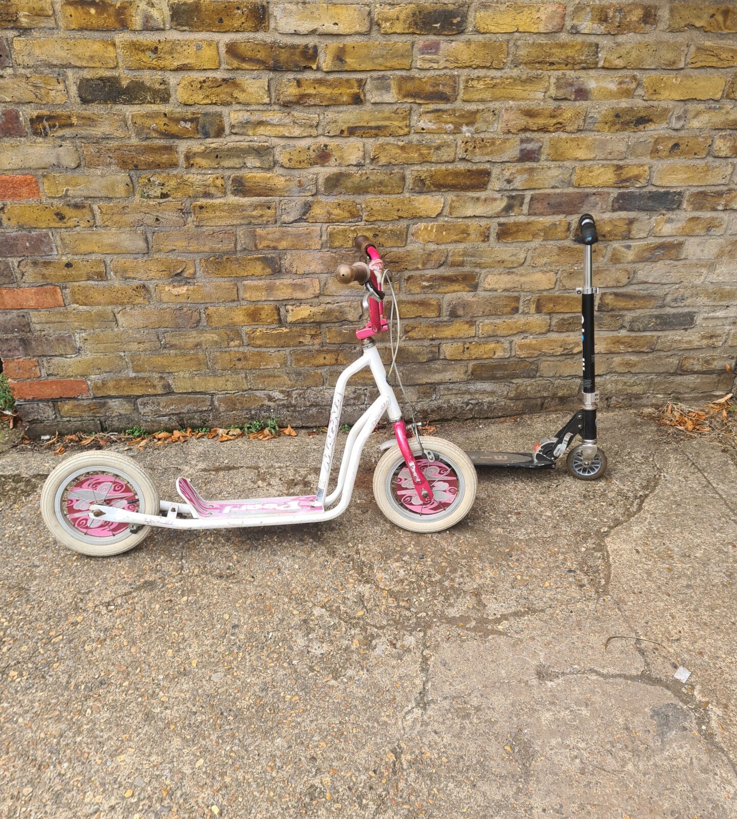 Pearl coloured childrens scooter for outdoor play.