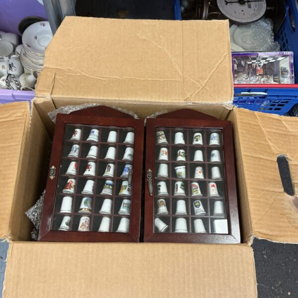 Large box containing a china thimble collection in display cases.